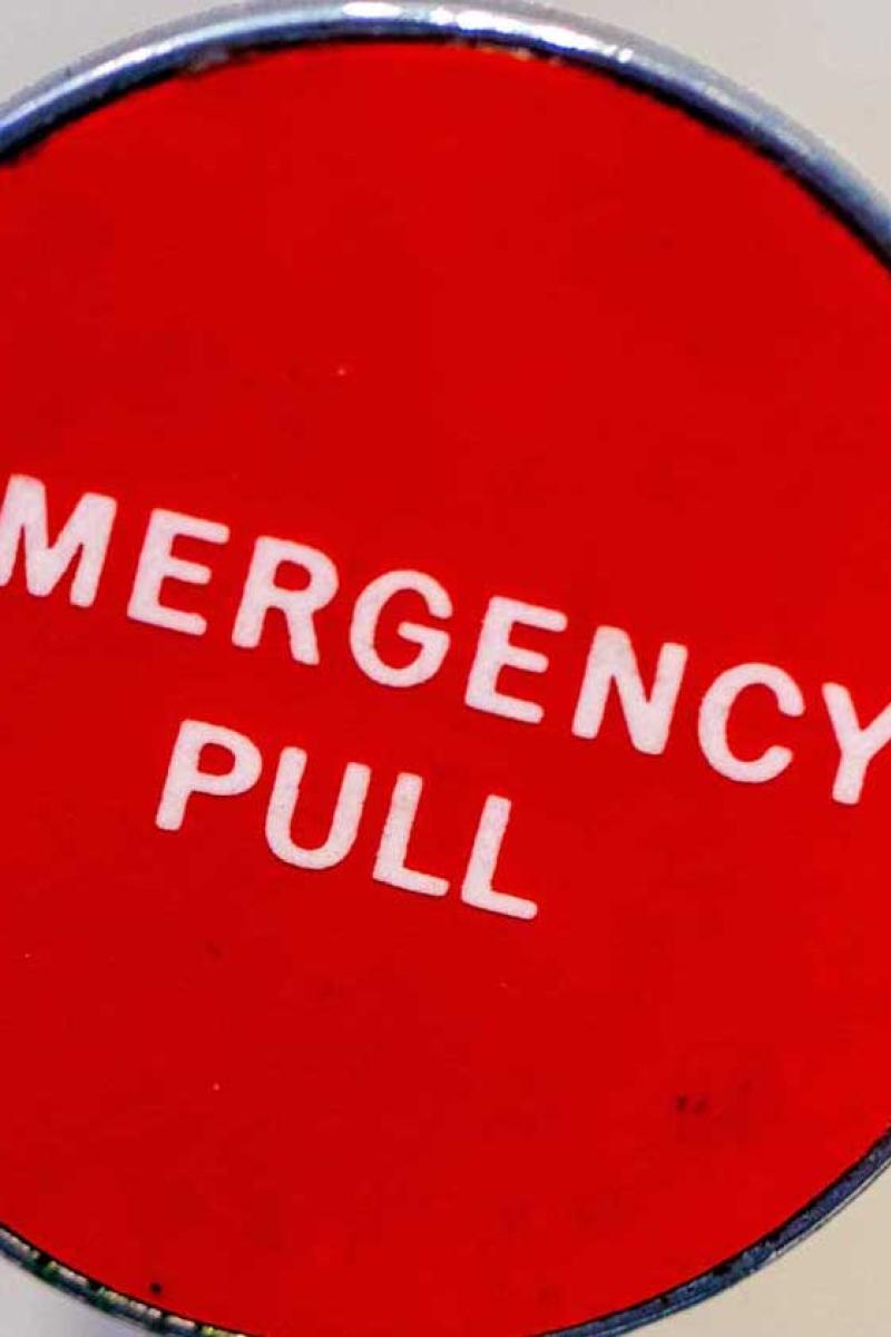 A red circle is a lever. Inside the circle, white text says, "Emergency Pull".